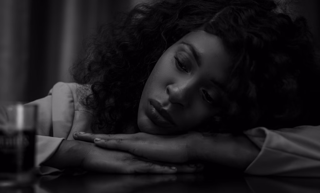 Don't Let Emotional Pain Steal Your Oil,Introspective black and white portrait of an African American woman at a table.